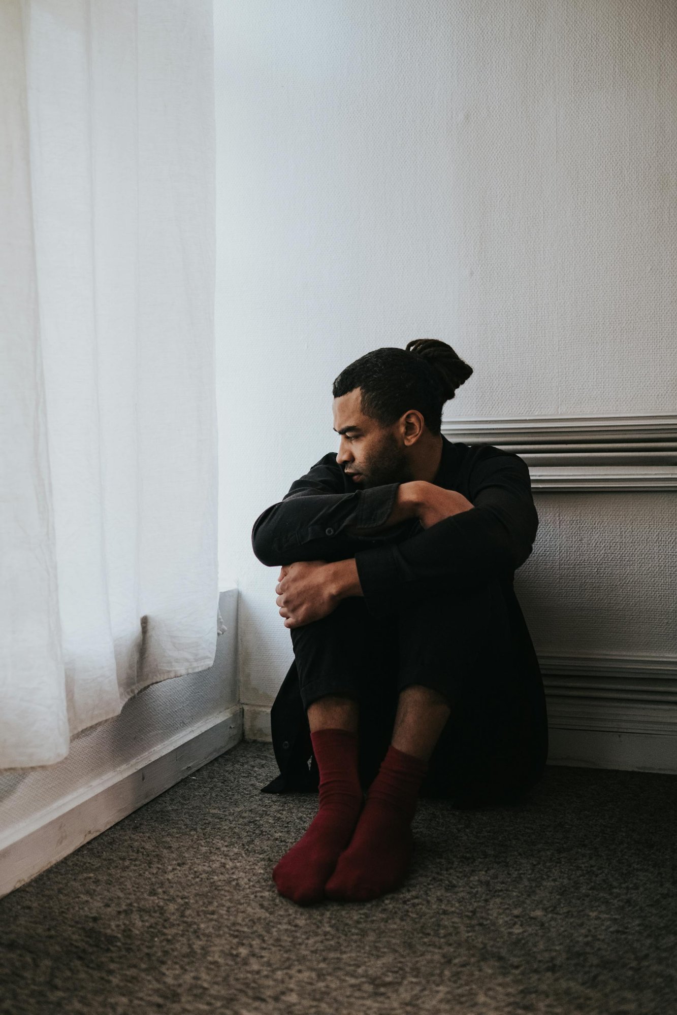 Man sitting with head down, experiencing fatigue